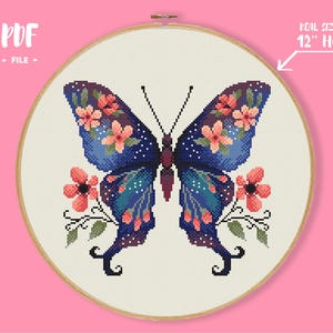 May include: Cross-stitch pattern of a butterfly with blue wings, adorned with pink flowers and green leaves, set against a cream background. The design is displayed in a 12-inch hoop. Text on the image reads "PDF - FILE".