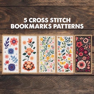 May include: Five rectangular cross stitch bookmark patterns featuring floral and butterfly motifs in various color palettes, including white, orange, yellow, blue, and black backgrounds, with the text 5 CROSS STITCH BOOKMARKS PATTERNS.
