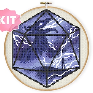 May include: A cross-stitch pattern kit featuring a purple and blue geometric design with a dragon inside. The design is in the shape of a 20-sided die.