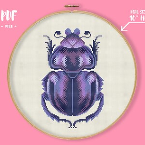 Könnte beinhalten: Ein Kreuzstichmuster eines lila Skarabäus-Käfers, dargestellt in einem 25 cm-Reifen. Das Design weist Lila- und Blautöne auf. Der Text "PDF FILE" befindet sich oben links.