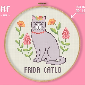 Peut inclure: Broderie au point de croix d'un chat gris avec une couronne et un collier de fleurs, entour&eacute; de fleurs. Le texte "FRIDA CATLO" est brod&eacute; en dessous. Le motif est dans un cercle de 25.4 cm, avec le texte "PDF FILE".