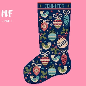 May include: A navy blue Christmas stocking with a cross-stitch design. The stocking is decorated with ornaments, birds, and holly. The name "JENNIFER" is stitched at the top. The background is pink.