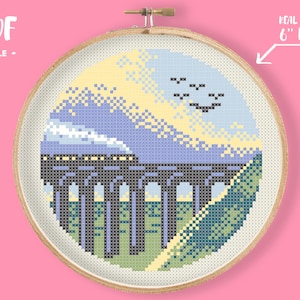 May include: A cross-stitch pattern of a train on a bridge with a blue sky and yellow clouds. The pattern is in a 6-inch hoop. "PDF FILE" is written at the top of the image.