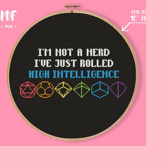 May include: Cross-stitch embroidery in a wooden hoop with the text "I'M NOT A HERD I'VE JUST ROLLED HIGH INTELLIGENCE" and colorful dice graphics. The hoop is approximately 10 inches in diameter. The background is black.