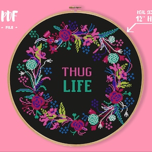 May include: A black embroidery hoop with a floral wreath design and the text "THUG LIFE" in the centre. The hoop is 12 inches in diameter.