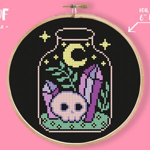 May include: Cross-stitch pattern in a wooden hoop. The design features a skull, crystals, and a crescent moon inside a jar, with the text "PDF FILE" and "REAL SIZE IN 6" HOOP". The background is black.