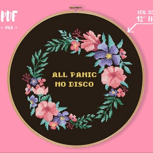 May include: A black embroidery hoop with a floral wreath design and the text "ALL PANIC NO DISCO" in yellow. The hoop is 12 inches in diameter.