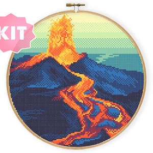 Peut inclure: Un motif de point de croix représentant un volcan en éruption avec de la lave orange et jaune coulant sur le flanc de la montagne. L'arrière-plan est un dégradé bleu et vert.
