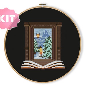 Peut inclure: Un kit de point de croix représentant un livre avec une fenêtre s'ouvrant sur une scène enneigée avec une personne debout devant un château. La fenêtre est encadrée de bois brun et le livre est ouvert avec des pages dans des tons de brun.