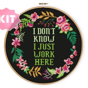 May include: A black embroidery hoop with a floral wreath design and the text "I don't know I just work here".