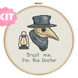 May include: Cross stitch pattern kit featuring a plague doctor wearing a black hat and mask with a lantern. The text reads "Trust me. I'm the Doctor."