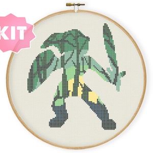 May include: Cross stitch pattern kit featuring a green and yellow pixelated figure holding a sword, with a forest scene inside the figure.