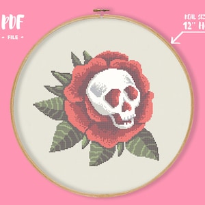 Könnte beinhalten: Kreuzstichmuster eines weißen Schädels in einer roten Rose mit grünen Blättern. Das Muster ist für einen 30 cm großen Rahmen konzipiert. PDF-Datei.