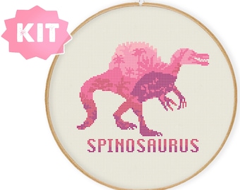 May include: A pink and purple cross-stitch pattern of a Spinosaurus dinosaur in a hoop. The pattern includes the text "Spinosaurus".