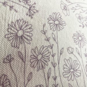 May include: A white background with a pattern of purple flowers and leaves. The flowers are stylized and have a simple design.