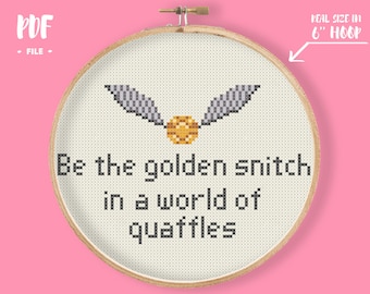 May include: Cross-stitch embroidery in a wooden hoop. The design features a golden snitch with the text "Be the golden snitch in a world of quaffles." The hoop is 6 inches in diameter. The PDF file is included.
