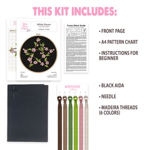 May include: Cross stitch kit featuring a floral star design. The kit includes a black Aida fabric, embroidery floss, a needle, and instructions. The kit is packaged in a white box with the words "White Raven Patterns" printed on it.