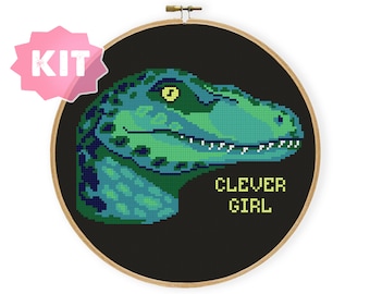 May include: Cross stitch pattern kit featuring a green and blue dinosaur with the text "Clever Girl" in yellow.