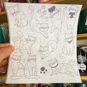 Può includere: Tessuto bianco con un motivo ripetuto di disegni a linea nera e bianca di gatti in varie pose. I gatti sono tutti stilizzati e hanno tratti semplici. Il tessuto è perfetto per progetti di artigianato, come la creazione di borse tote, cuscini o trapunte.