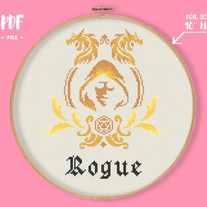 May include: Cross-stitch design in a 10-inch hoop featuring a gold dragon crest with the word "Rogue" in black gothic lettering. The design includes a PDF file. The background is a light beige fabric.