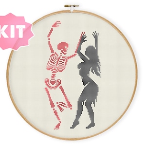 May include: Cross stitch pattern kit featuring a red skeleton and a black silhouette of a woman dancing together. The pattern is in a circular hoop.