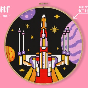 May include: Cross-stitch design of a spaceship in space, featuring a red, orange, and yellow ship against a black background with planets and stars. The design is in a 10-inch hoop. Text reads "PDF FILE".