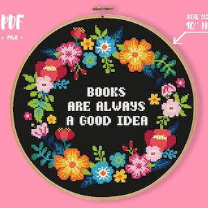 May include: A black and white cross stitch pattern with a floral wreath and the text "BOOKS ARE ALWAYS A GOOD IDEA". The pattern is designed to fit a 10-inch embroidery hoop.