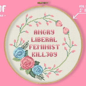 May include: Cross stitch pattern featuring a floral wreath with pink and blue roses and the text "Angry Liberal Feminist Killjoy" in pink lettering. The pattern is designed for an 8-inch hoop.