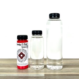 Puede incluir: Tres botellas de líquido transparente, una botella roja con tapa negra y el texto "Ready-2-Pour Acrylic Pouring Medium Limited Edition" y un diseño de mandala rojo con el texto "I AM" repetido alrededor del mandala.