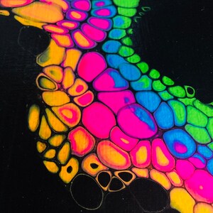 Puede incluir: Pintura abstracta con fondo negro y un dise&ntilde;o colorido de c&iacute;rculos amarillos, naranjas, rosas, azules y verdes. Los c&iacute;rculos est&aacute;n dispuestos en un patr&oacute;n fluido, creando una sensaci&oacute;n de movimiento.