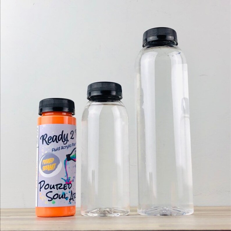 Puede incluir: Tres botellas de pl&aacute;stico transparentes con tapas negras. La botella m&aacute;s peque&ntilde;a est&aacute; llena de pintura naranja y tiene el texto "Ready 2 Pour Fluid Acrylic Paint" y "Poured Soul Art" en la etiqueta.