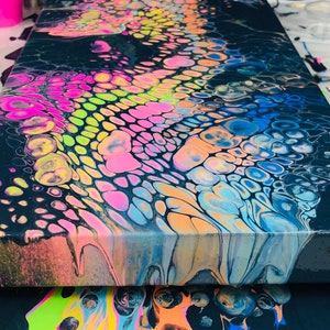 Puede incluir: Pintura abstracta sobre lienzo con fondo negro y remolinos coloridos de rosa, azul, verde y amarillo.