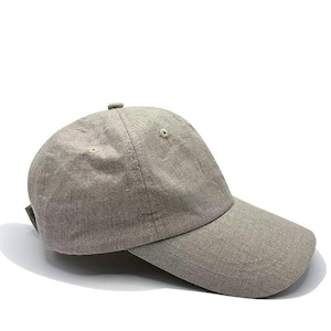 Puede incluir: Gorra de béisbol gris claro con visera curva. La gorra tiene un diseño sencillo con una correa de tela en la parte trasera para ajustarla. Está hecha de un material texturizado y tiene un pequeño botón en la parte superior.