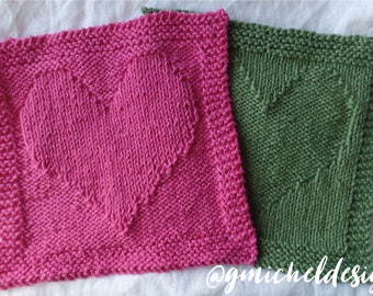 May include: Two knitted dishcloths with a heart design. One is pink and the other is green. The dishcloths are on a white surface. @gnicholdesign