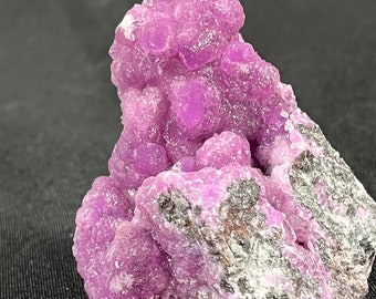 May include: A cluster of vibrant purple cobalt calcite crystals on a gray matrix. The crystals have a botryoidal, or grape-like, formation.