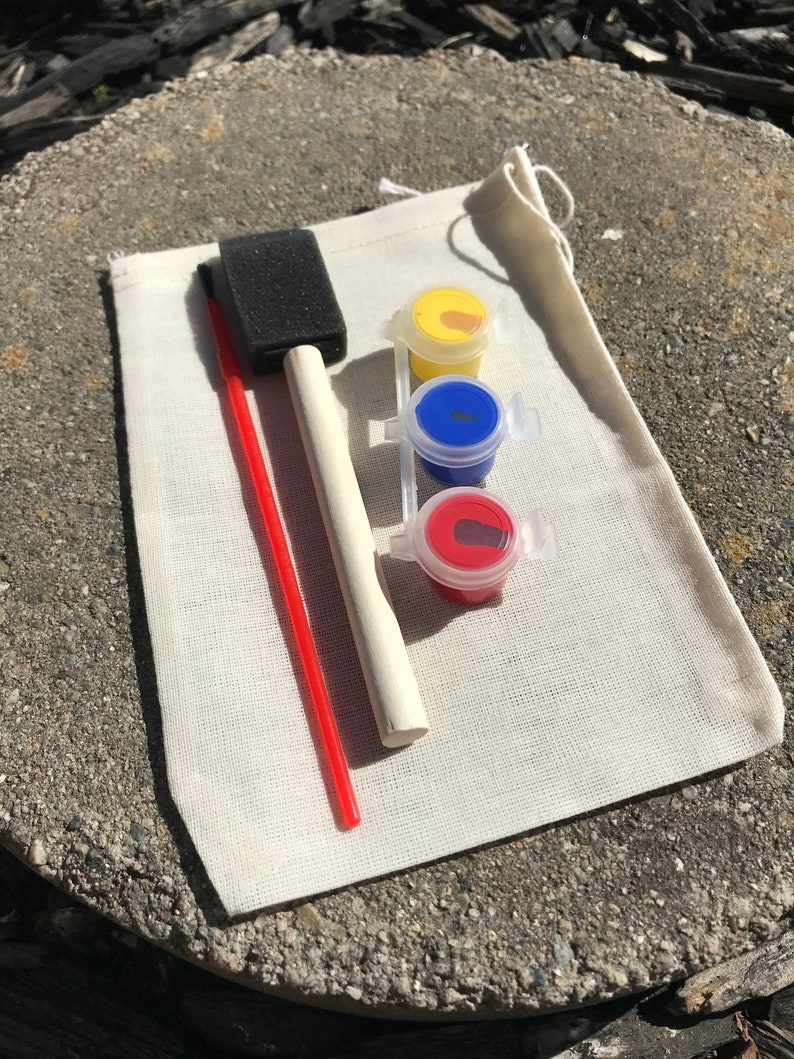 May include: A small art kit with a canvas bag, a red paintbrush, a sponge brush, and three small paint pots with yellow, blue, and red paint. The kit is designed for painting projects.