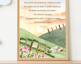 May include: A framed watercolor print featuring a pastoral scene with text from Psalm 23:1-3. The artwork depicts a sunset over green hills, a fence, and two sheep. Pink flowers and a wooden frame complete the design.