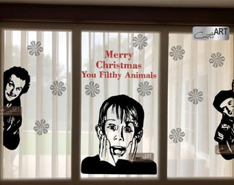 May include: A set of black vinyl window decals featuring a central portrait of a boy with hands on his face, flanked by two side figures, surrounded by snowflake shapes and the red text Merry Christmas You Filthy Animals.