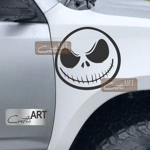 May include: A white car with a black and white Jack Skellington decal on the side. The decal is a close-up of Jack Skellington's face from the movie The Nightmare Before Christmas. The decal is on the side of the car, near the front wheel.