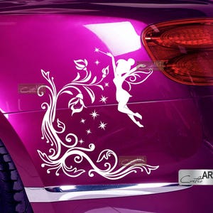 May include: White vinyl decal of a fairy with wings and a wand, flying over a floral design. The decal is applied to the side of a pink car.