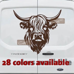 May include: A brown Highland cow head decal on a white van. The decal shows a detailed illustration of the cow's face, including horns and shaggy fur. Text at the bottom reads "28 colours available".
