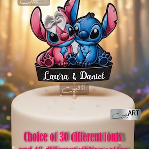 Peut inclure: Un cake topper avec les personnages de dessins animés Stitch et Angel, avec les noms "Laura & Daniel" sur une bannière noire. Le topper est sur un gâteau blanc avec le texte "Choix de 30 polices différentes et 18 couleurs de ruban différentes."
