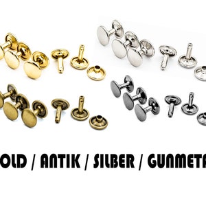 May include: Assortment of metal rivets in gold, antique brass, silver, and gunmetal finishes. The rivets are in various stages of assembly, with some having the top and bottom pieces attached and others having the post attached.