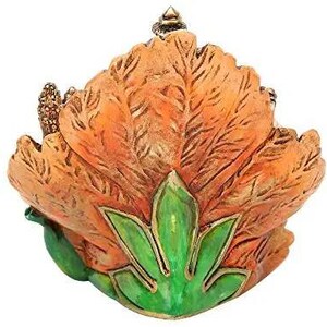 May include: A decorative trinket box shaped like a flower with orange petals and green leaves. The box is made of ceramic and has a detailed design.