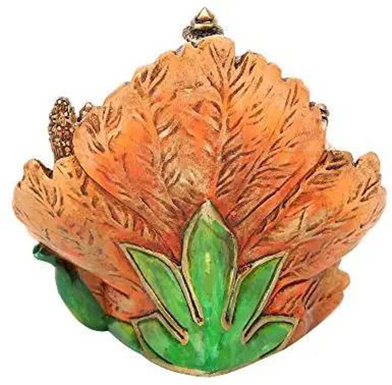 May include: A decorative trinket box shaped like a flower with orange petals and green leaves. The box is made of ceramic and has a detailed design.