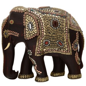 May include: A dark brown wooden elephant figurine decorated with gold, copper, and colorful gemstones. The elephant has a raised trunk and is standing on all four legs.