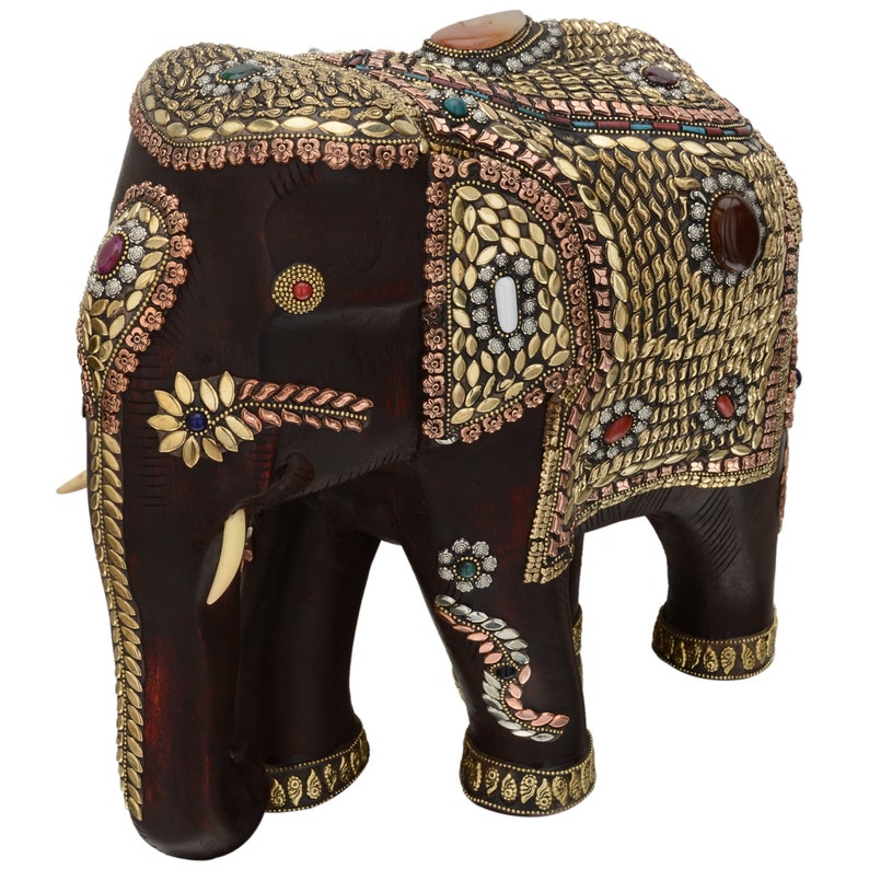 May include: A dark brown wooden elephant figurine with intricate gold and silver detailing. The elephant is decorated with colorful gemstones and has a raised trunk.