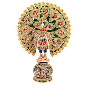 May include: A decorative peacock figurine with an elaborate design. The peacock features a vibrant green, red, blue, and gold color scheme. The peacock's tail is fanned out, and the figurine is mounted on a decorative base. The base is black with gold and red floral patterns.