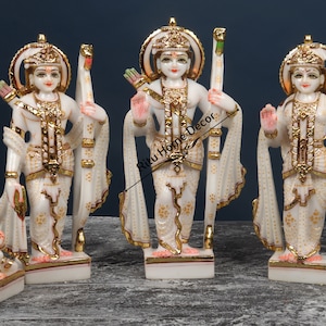 Puede incluir: Conjunto de estatuas de mármol blanco que representan a las deidades hindúes Rama, Sita y Lakshmana. Las estatuas están intrincadamente talladas y pintadas con detalles dorados. El conjunto también incluye una pequeña estatua de Hanuman, el devoto leal de Rama.