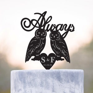 Puede incluir: Silueta negra de dos búhos posados en una rama con un corazón que dice "S & F 01.10.19" y la palabra "Always" encima. Este es un adorno para la torta de bodas.